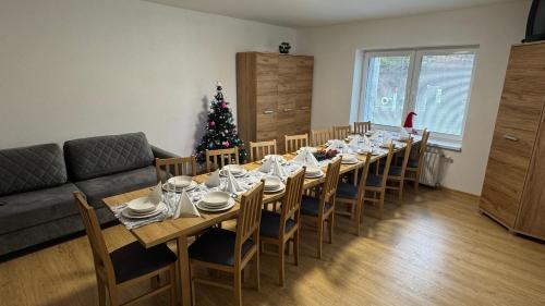 a living room with a long table and a christmas tree at Ubytovanie U Mirca in Nová ľubovňa