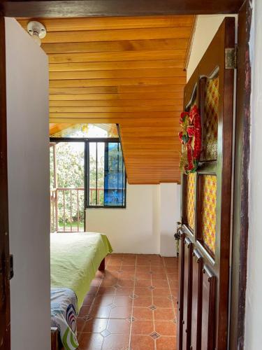 a hallway of a house with a bed and a window at Hostal Pachamama in San Agustín