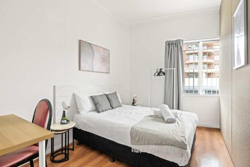 a bedroom with a bed and a table and a window at Double Room in Kingsford - Next to the Station - Shared Bathroom in Sydney