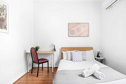 a bedroom with a bed and a desk with a chair at Double Room in Kingsford - Next to the Station - Shared Bathroom in Sydney