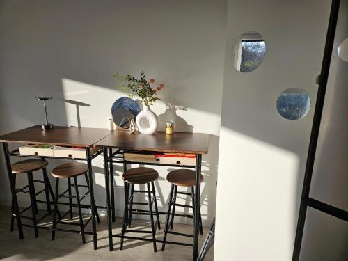 - une cuisine avec une table et quelques tabourets dans l'établissement Lit simple -canapé lit dans appt partagé, à Noisy-le-Grand