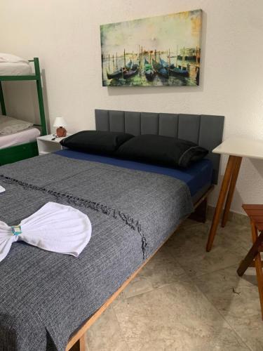 a bedroom with two beds and a painting on the wall at Pousada Casa da Penha in Abraão