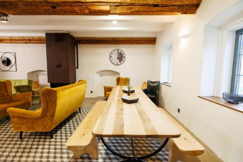 a living room with a wooden table and yellow chairs at Horní Strakův mlýn in Úštěk