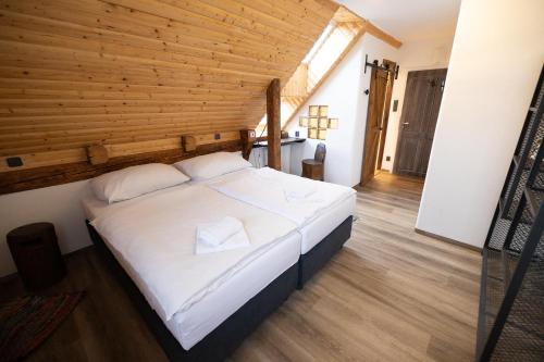 a large bed in a room with a wooden ceiling at Horní Strakův mlýn in Úštěk
