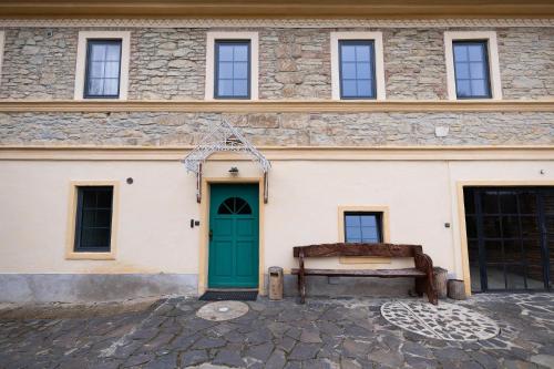 a building with a green door and a bench at Horní Strakův mlýn in Úštěk