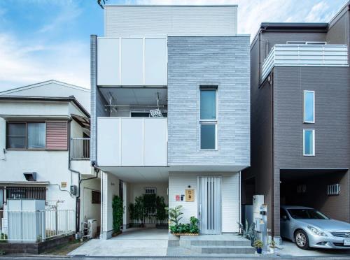 a house with a silver car parked in front of it at 悠静Osaka in Osaka