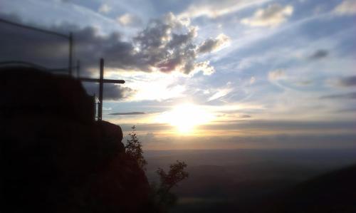 a cross on a hill with the sunset in the background at Apartment Rychtrovna in Hejnice
