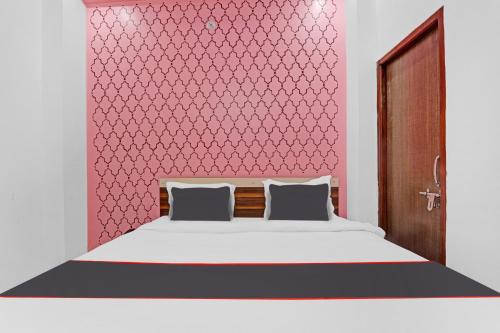 a bedroom with a white bed and a red wall at Collection O Shivashakti Grand Near Chaudhary Charan Singh International Airport in Banthra Sikandarpur