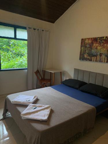 a bedroom with a bed with two towels on it at Pousada Casa da Penha in Abraão
