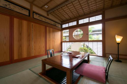 a dining room with a wooden table and chairs at Sekitaitei Ishida in Achi
