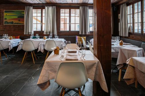 two pictures of a restaurant with tables and chairs at Hotel & Restaurant Zum Schwarzen Bären in Andermatt