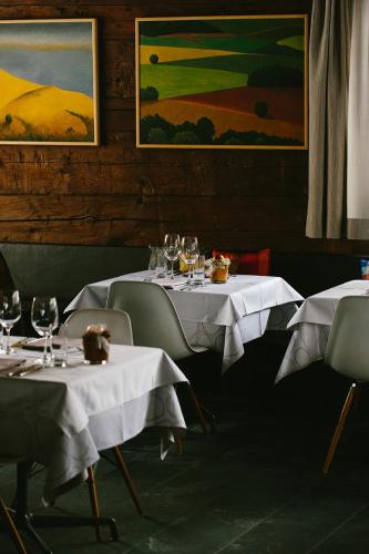 two tables in a restaurant with white table cloths at Hotel & Restaurant Zum Schwarzen Bären in Andermatt