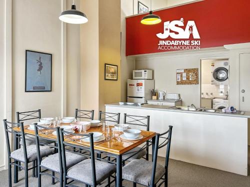 a dining room with a table and chairs and a counter at Razorback 2 in Jindabyne
