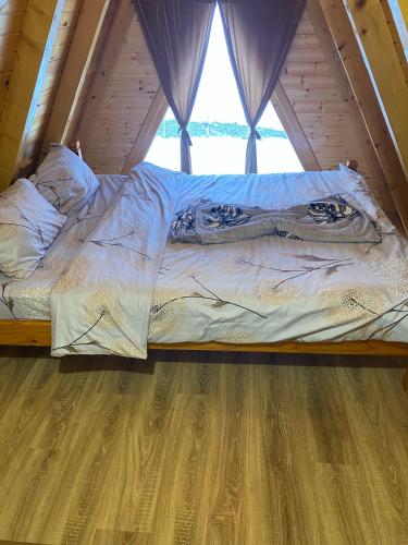 a bed in a wooden room with a window at Villa Alpina in Boge