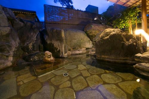 a pool of water in a room with rocks at Sekitaitei Ishida in Achi