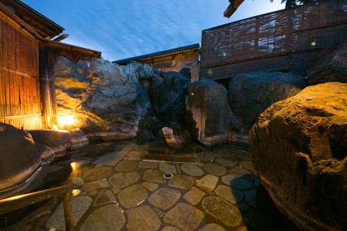 a room with rocks and a building with a pool of water at Sekitaitei Ishida in Achi