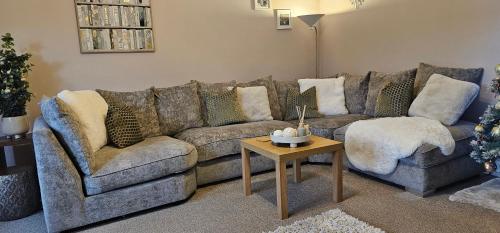 a living room with a couch and a table at Balmore Farmhouse near Lochness in Inverness