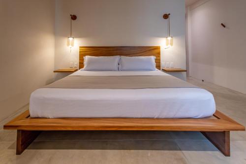a bedroom with a large bed with a wooden headboard at Casa Los Dichos in Brisas de Zicatela