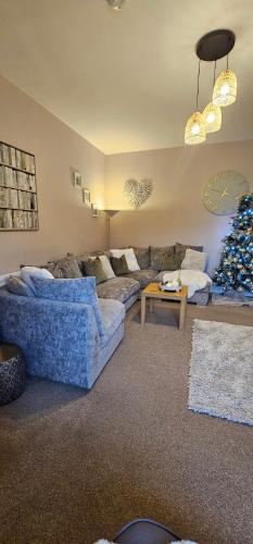 a living room with a couch and a christmas tree at Balmore Farmhouse near Lochness in Inverness