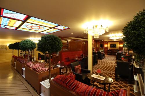 a lobby with couches and tables and a chandelier at Hotel Strandperle in Cuxhaven