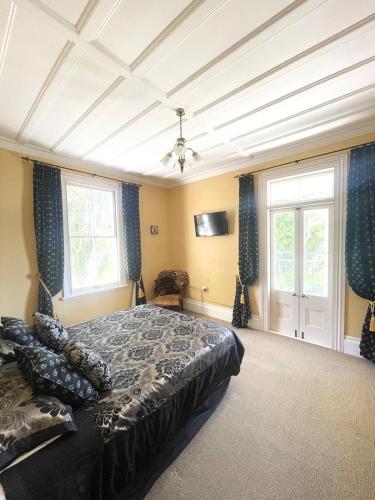 a bedroom with a bed and two windows at Blue Seas Villa in Napier