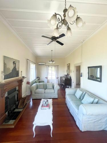 a living room with two couches and a ceiling fan at Blue Seas Villa in Napier
