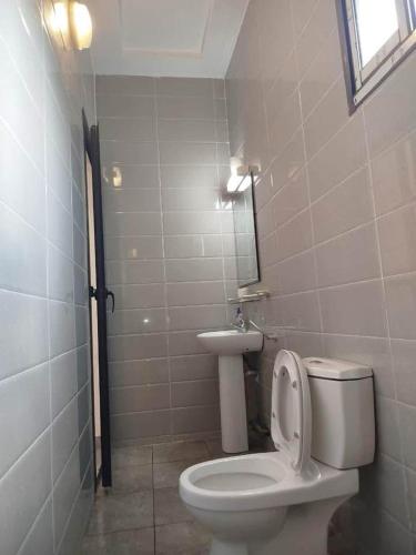 a bathroom with a toilet and a sink at Résidence Ahydeney in Abidjan