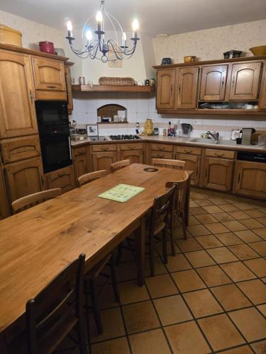 une grande cuisine avec une table et des chaises en bois dans l'établissement La rainette, à Chaux