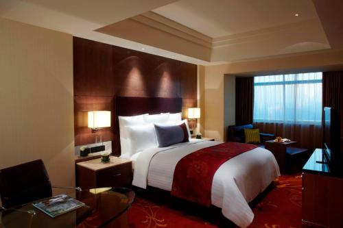 a hotel room with a bed and a television at Suzhou Marriott Hotel in Suzhou