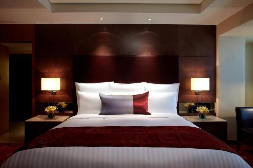 a bedroom with a large bed with two lamps at Suzhou Marriott Hotel in Suzhou