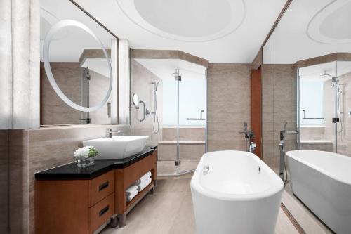 a bathroom with a tub and a toilet and a sink at Suzhou Marriott Hotel in Suzhou