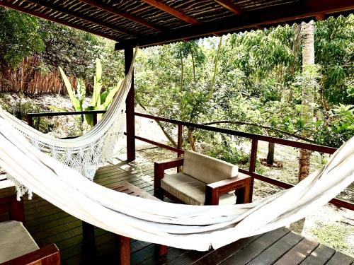 a porch with a hammock and a chair on a deck at Alto Atins in Atins