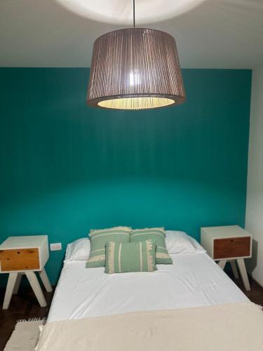 a bedroom with a bed with a green wall at Carlis Home in Cordoba