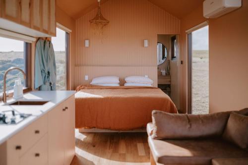 a bedroom with a bed and a couch in a room at EyreWay in Tulka