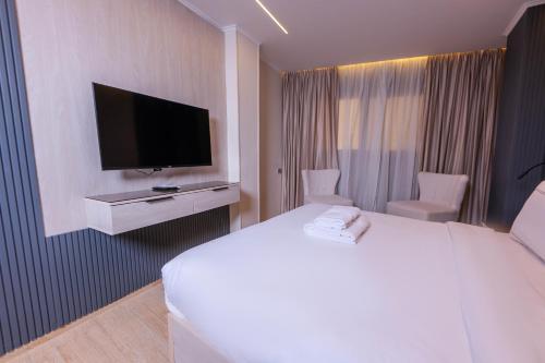 Una habitación de hotel con una cama y un televisor de pantalla plana. en Remal Pyramids Hotel, en El Cairo