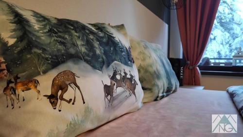 a pillow with a painting of giraffes on a bed at Pinewood ANG luxurious apartment A43, Borovets Gardens in Borovets