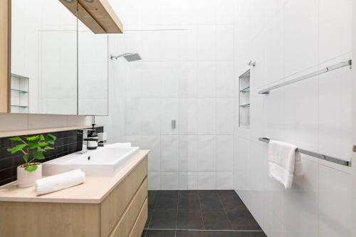 a white bathroom with a sink and a shower at Lily Pad Retreat - A Luxe Poolside Parap Oasis in Paraparap