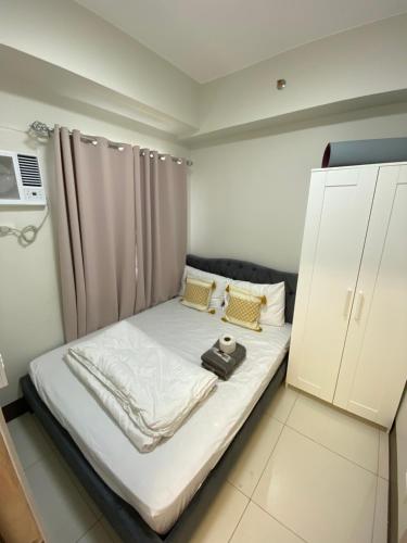 a bed in a small room with at Aesthetic Vibes Condo 2br Near Airport in Manila