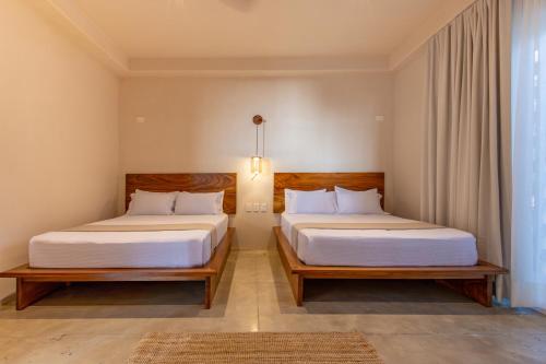 a bedroom with two beds and a window at Casa Los Dichos in Brisas de Zicatela