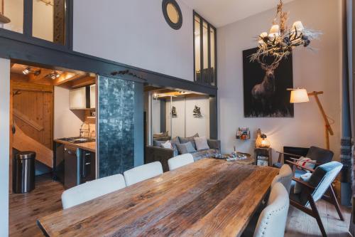 - une salle à manger et un salon avec une table et des chaises en bois dans l'établissement L'Eveil - 65m2 - 6-8P - Centre Ville Cauterets, à Cauterets