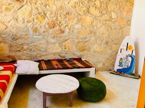 アガディールにあるCozy 1BR Bungalow with Kitchen in Eco Garden Nature Escapeのベッド1台、スツール1台、壁