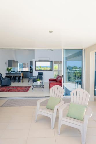 a living room with two chairs and a couch at Azure Sea Whitsunday Resort in Airlie Beach