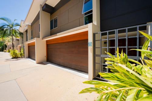 a house with a garage door in front of it at Azure Sea Whitsunday Resort in Airlie Beach