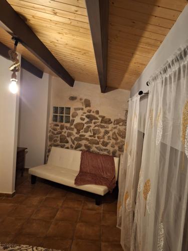 a room with a stone wall and a white bench at La Escondida in Burgohondo