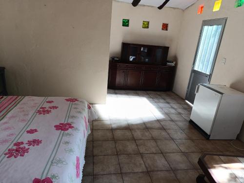 a room with a bed and a small refrigerator at casa y monoambiente Britopolis in Fomento