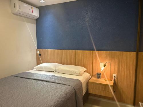 a bedroom with a bed and a blue wall at ER1208 - Apartamento aconchegante em São Luís in São Luís