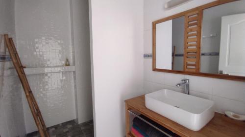 a bathroom with a sink and a mirror at L'Îlot de la Marina in Le Marin