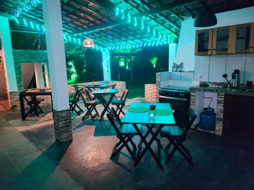 a group of tables and chairs in a kitchen with lights at Pousada Estrela Feliz in Canavieiras