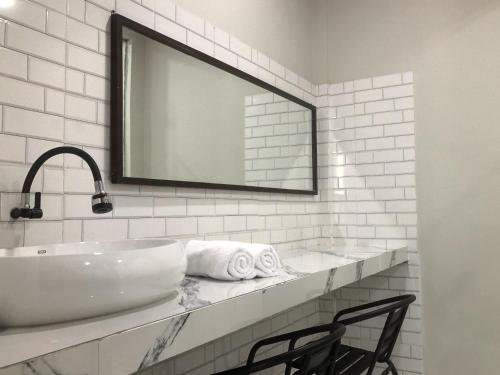 a bathroom with a sink and a mirror and a chair at Sekar Arum Riverside Resort in Canggu in Tanah Lot
