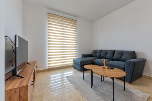 a living room with a blue couch and a table at Cozy apartment in Čajetina